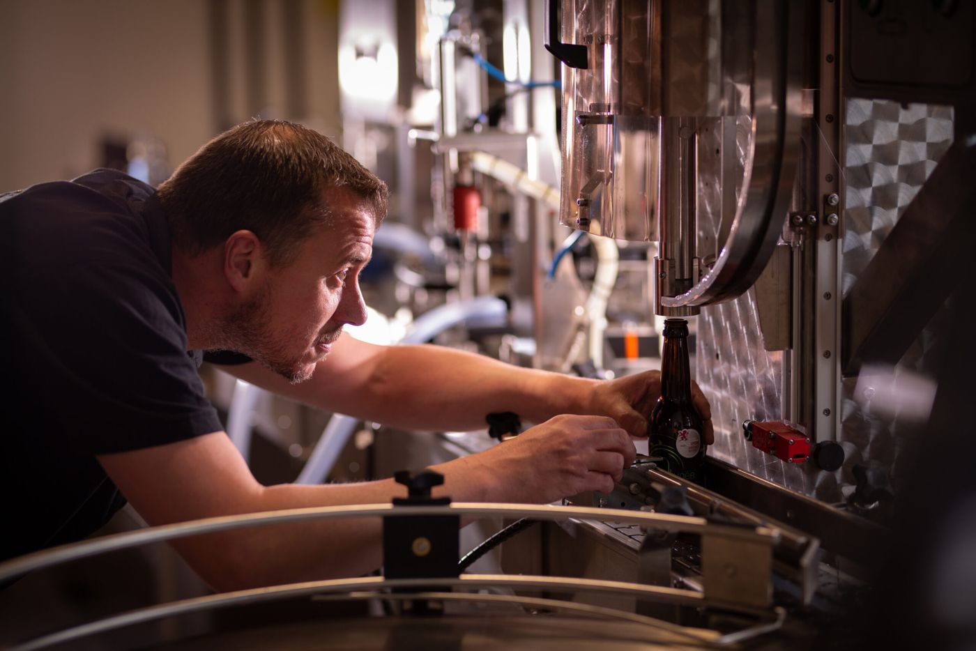 Un brasseur règle la ligne de mise en bouteille